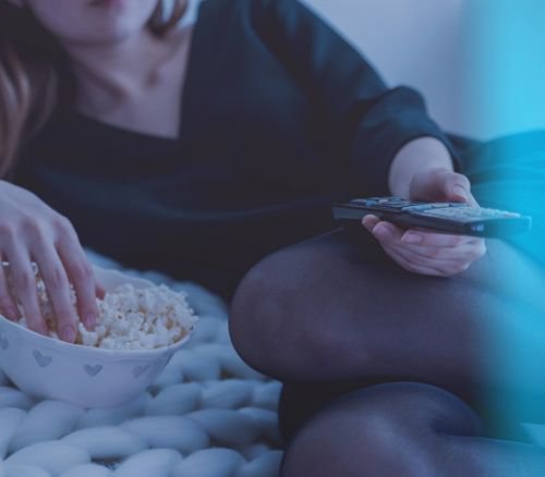 Woman with remote control and popcorn